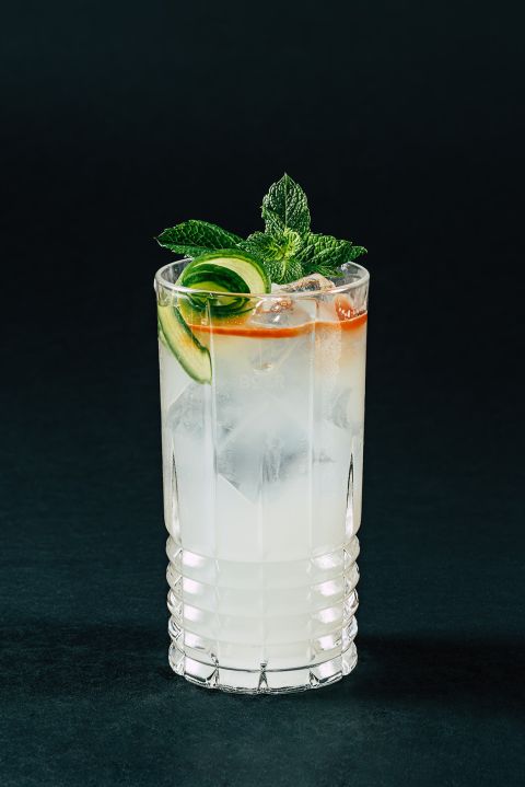 Ein Kristallglas mit BOAR London Mule, Gurke und Minze vor einem dunklen Hintergrund.