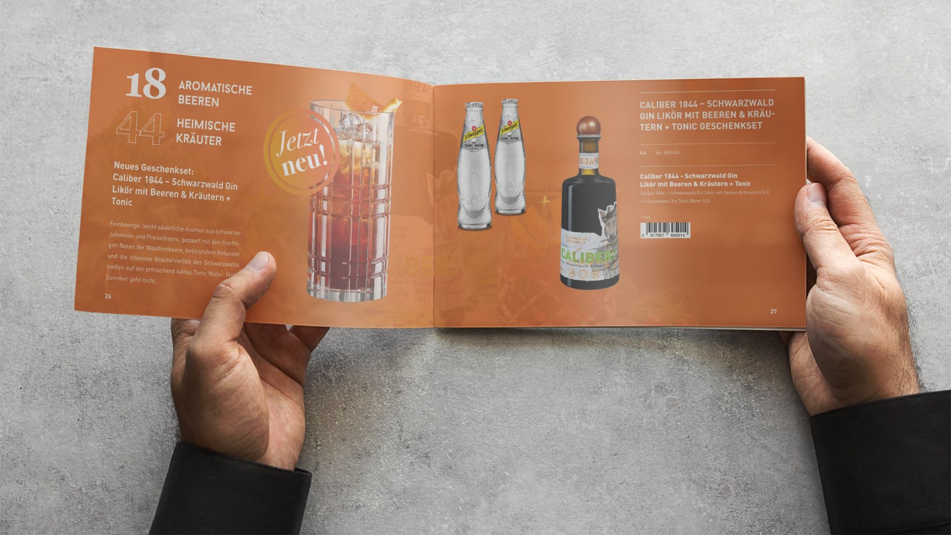 Zwei Hände halten eine aufgeschlagene Broschüre mit dem Produktsortiment von BOAR: auf orangenem Hintergrund ist dort eine Flasche Kräuterlikör neben Text abgebildet.