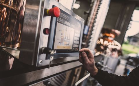 Digitale Steuerung einer Destillationsanlage mit Müller Controls Nahaufnahme einer digitalen Steuerungseinheit für eine Destillationsanlage, bedient mit einem Stift in einer Brennerei.
