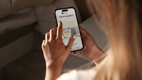 Hand hält ein Smartphone mit einem News-Beitrag zum Stein des Monats März von Jogerst Steintechnologie.