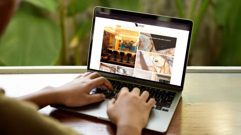 Person nutzt einen Laptop und betrachtet den Jogerst Steinshop mit Informationen zu Natursteinprojekten im Wohnbereich.