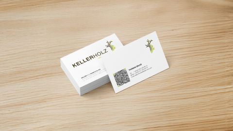 Stapel Kellerholz Visitenkarten auf Holzoberfläche, mit Logo, QR-Code und Kontaktdaten im minimalistischen Design.