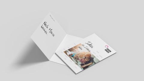 Aufgeklappte Verkaufsmappe von Ideenhaus mit Familie beim Kochen und dem Slogan „Ideen für Zuhause“.