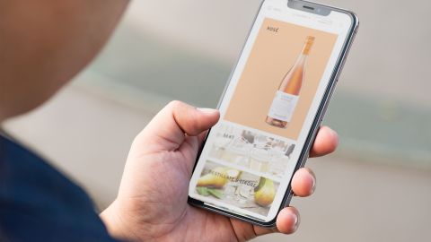 Ein Smartphone in der Hand einer Person, auf dem die Online-Vinothek von Männle geöffnet ist.