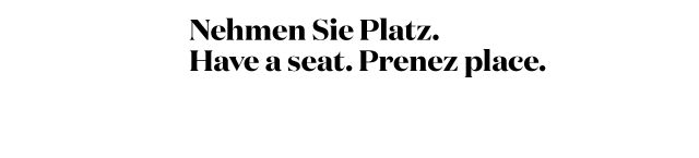 Schriftzug "Nehmen Sie Platz. Have a seat. Prenez place." in drei Sprachen auf weißem Hintergrund.