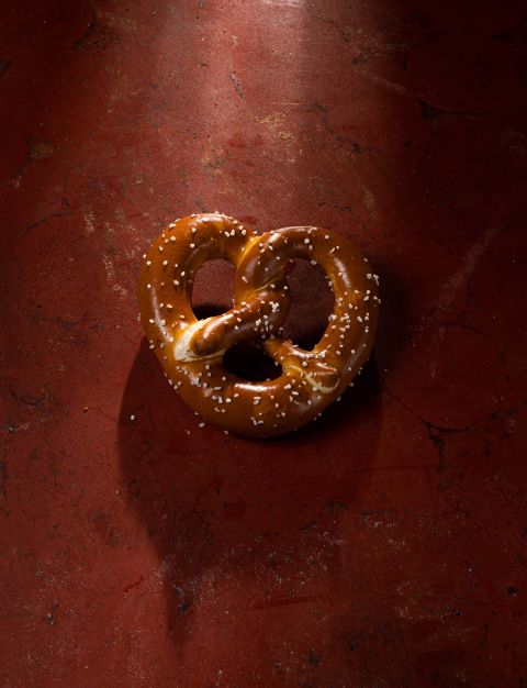 Eine herzförmige Brezel auf rotem Unergrund.