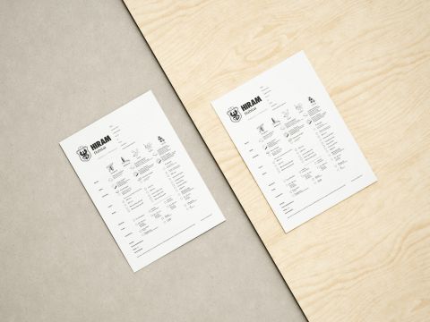 Zwei HIRAM Habitat Bestellformulare mit Produktoptionen und Logos auf hellem Holz- und grauem Betontisch