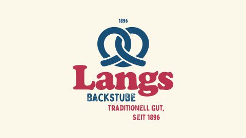 Logo von Langs Backstube mit blauer Abbildung einer Brezel und rotem Schriftzug „Traditionell gut, seit 1896“ auf hellem Hintergrund.