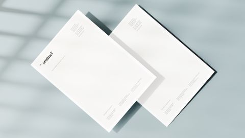 Zwei weiße Briefbögen mit Steimel-Logo, auf hellem Hintergrund, minimalistisch gestaltet für professionelle Markenkommunikation.
