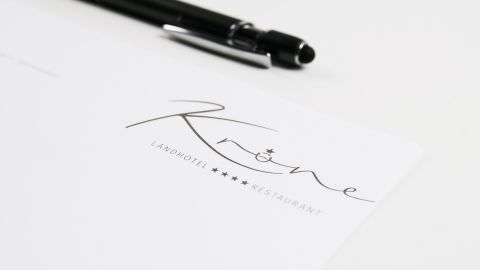 Landhotel Krone Briefbogen Nahaufnahme des Briefkopfs des Landhotels Krone mit einem eleganten schwarzen Stift auf weißem Hintergrund, der das stilvolle Logo-Design zeigt.