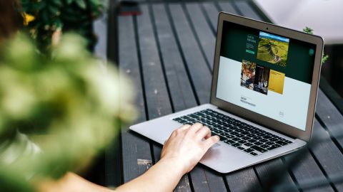 Auf einem MacBook, das auf einem Picknicktosch in der Natur steht, ist die Website vom Schwarzwaldweingut Andreas Männle geöffnet.