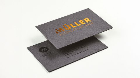 Visitenkarten von Müller Brennereianlagen Edle Visitenkarten von Müller Brennereianlagen in dunklem Design mit goldgeprägtem Logo und Kontaktdaten auf der Rückseite.